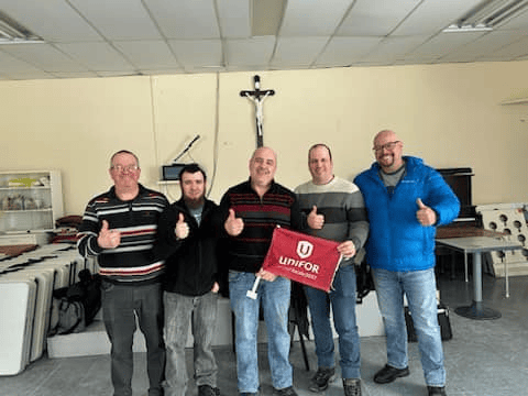 5 membres de la scierie Greenfirst à La Sarre souriant avec un drapeau unifor québec